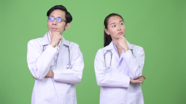 Jovens asiáticos casal médicos pensando juntos — Vídeo de Stock