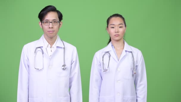 Jóvenes asiáticos pareja médicos con stop gesture juntos — Vídeo de stock