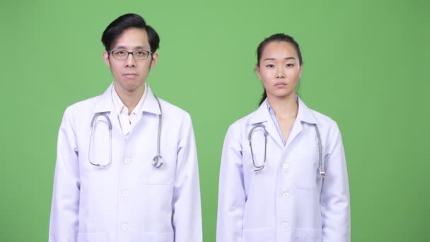 Jeune asiatique couple médecins avec arrêt geste ensemble — Video