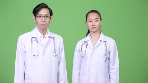 Jeune couple asiatique médecins ayant des décisions différentes ensemble — Video