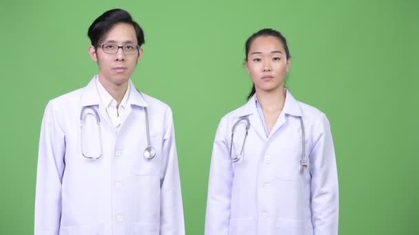 Jonge Aziatische paar artsen hebben verschillende besluiten samen — Stockvideo