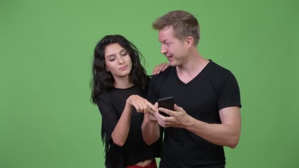 Pasangan muda menggunakan telepon bersama-sama — Stok Video