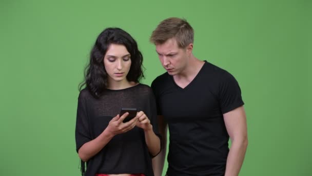 Pareja joven usando el teléfono juntos — Vídeo de stock