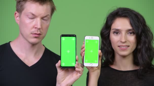 Nuori pari osoittaa puhelimen yhdessä — kuvapankkivideo