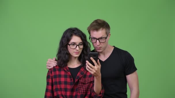 Casal jovem usando telefone e olhando chocado juntos — Vídeo de Stock