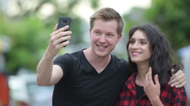 Jovem casal tomando selfie juntos ao ar livre — Vídeo de Stock