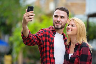 Genç çift telefon birlikte sokaklarda açık havada kullanma