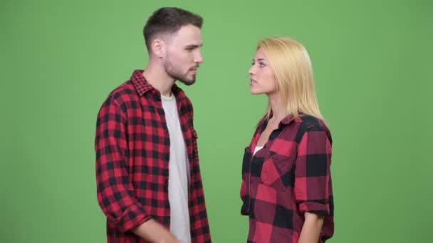 Junger Mann flüstert junger Frau zu und sieht aufgeregt aus — Stockvideo