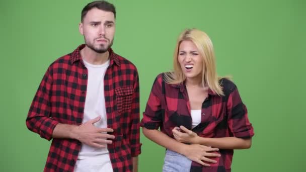 Mladý pár má žaludek bolet dohromady — Stock video