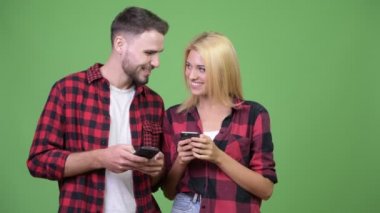 Telefon birlikte kullanırken gülümseyen genç mutlu çift