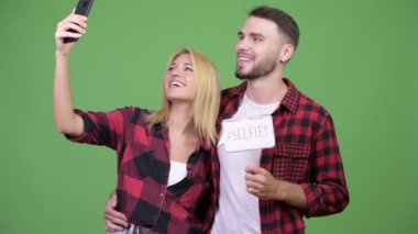 Genç çift kağıt basılı tutarak selfie alarak birlikte imzalamak