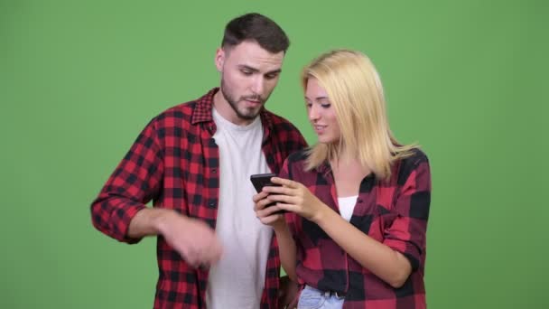 Νεαρό ζευγάρι χρησιμοποιώντας τηλέφωνο μαζί — Αρχείο Βίντεο