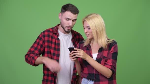 Casal jovem usando telefone juntos — Vídeo de Stock