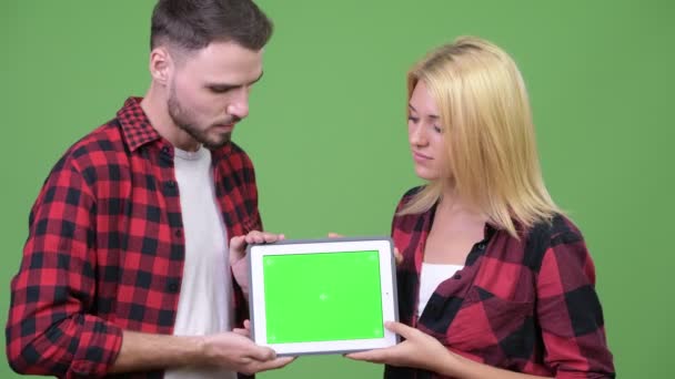 Pareja joven mostrando tableta digital juntos — Vídeo de stock