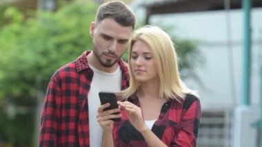 Genç mutlu çift telefon birlikte sokaklarda açık havada kullanma