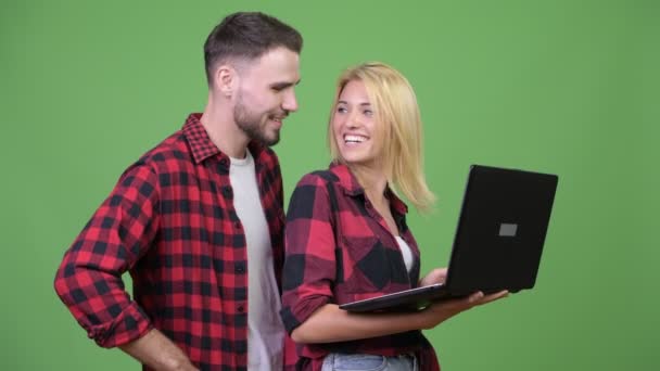 Jovem casal feliz sorrindo ao usar laptop juntos — Vídeo de Stock