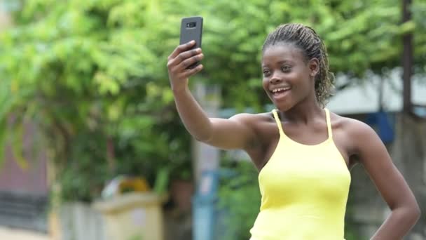年轻快乐非洲妇女使用电话户外 — 图库视频影像