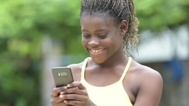 Νέοι ευτυχισμένη γυναίκα αφρικανική χρησιμοποιώντας τηλέφωνο σε εξωτερικούς χώρους — Αρχείο Βίντεο