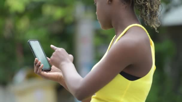 Mujer africana joven usando el teléfono al aire libre — Vídeo de stock