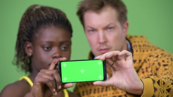 Genç çok etnik gruptan oluşan çift gösteren telefon birlikte — Stok video