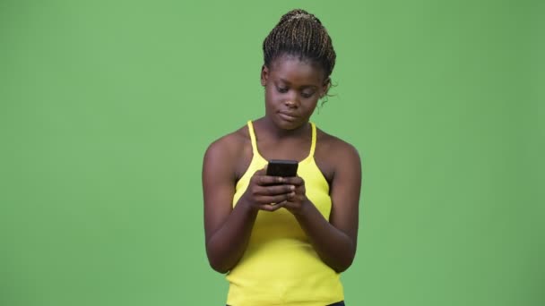 Νεαρή Αφρικανή γυναίκα χρησιμοποιώντας το τηλέφωνό — Αρχείο Βίντεο