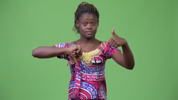 Jovem mulher africana escolhendo entre polegares para cima e polegares para baixo — Vídeo de Stock