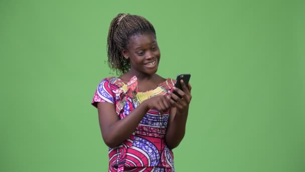 Young African woman using phone and getting good news — Stock Video