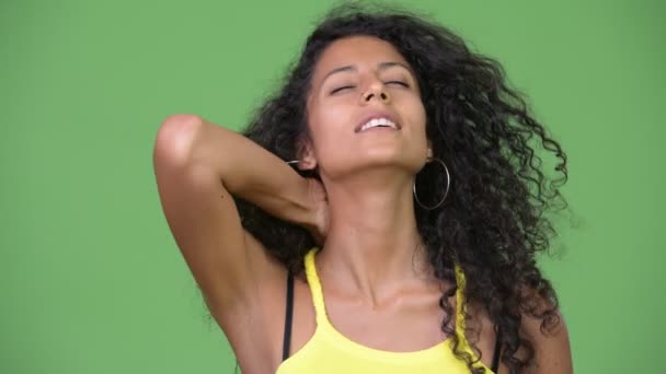 緑の背景にクロマキーに対して巻き毛を持つ若い美しいヒスパニック系女性のスタジオ撮影 — ストック動画