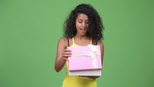 Joven hermosa mujer hispana mirando sorprendida al abrir la caja de regalo — Vídeos de Stock