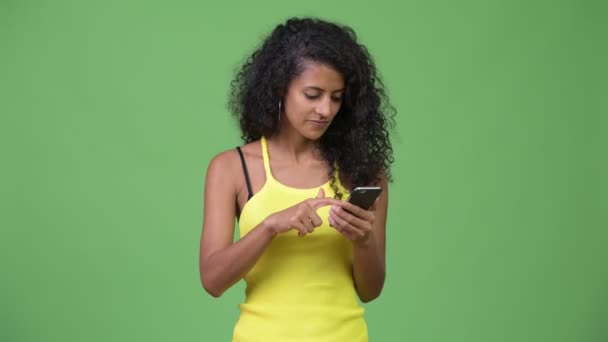 若くてきれいなヒスパニック系女性の携帯電話を使用して、良いニュースを取得 — ストック動画