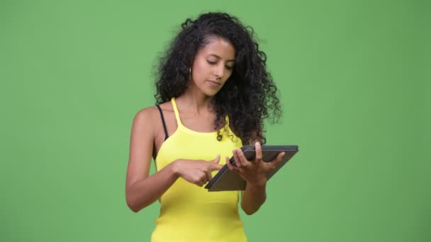 Jovem bela mulher hispânica pensando ao usar tablet digital — Vídeo de Stock