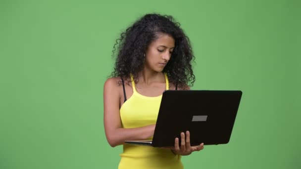 Giovane bella donna ispanica pensando durante l'utilizzo del computer portatile — Video Stock