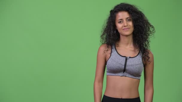Mooie Hispanic jongedame met gym kleren iets tonen — Stockvideo