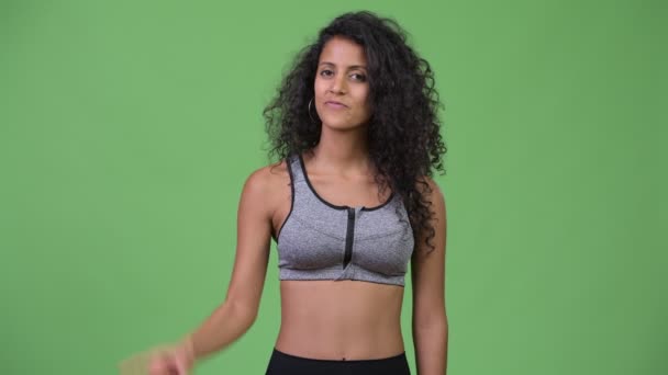 Young beautiful Hispanic woman with gym clothes pointing up — Stock Video