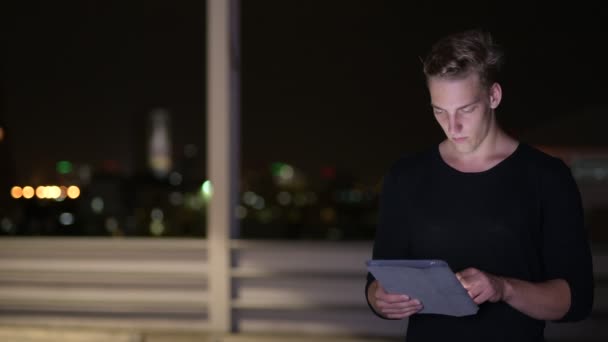 Homme en plein air la nuit en utilisant la tablette numérique — Video