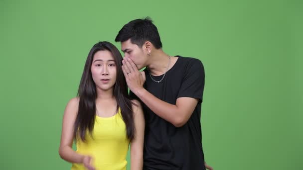 Jeune couple asiatique chuchotant les uns aux autres — Video