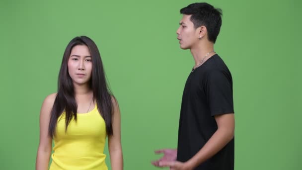Joven mujer asiática mostrando stop gesture a joven enojado hombre asiático — Vídeos de Stock
