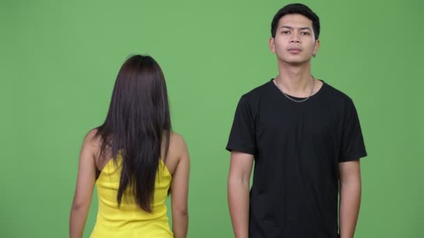 Jovem homem asiático com jovem mulher asiática olhando para trás — Vídeo de Stock