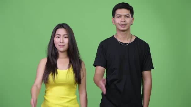 Молодая счастливая азиатская пара, пожимая друг другу руки — стоковое видео