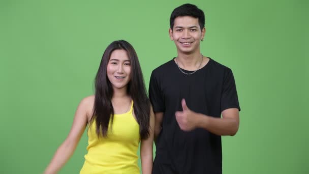 アジア系の若いカップル与える親指を一緒に — ストック動画
