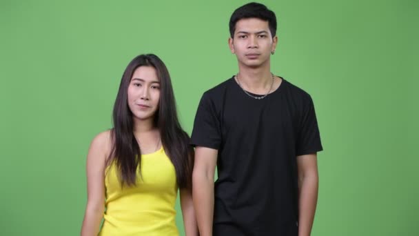 Young Asian couple pointing at camera together — Stock Video