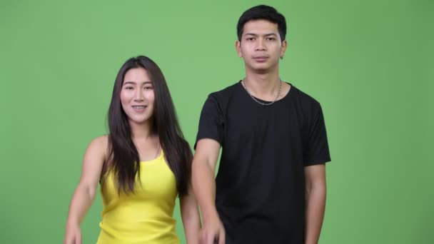 Unga asiatiska par pekar på kameran tillsammans — Stockvideo