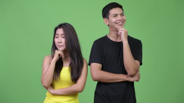 Молодая азиатская пара думает вместе иначе — стоковое видео