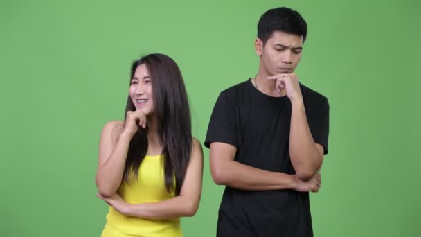 Молодая азиатская пара думает вместе иначе — стоковое видео