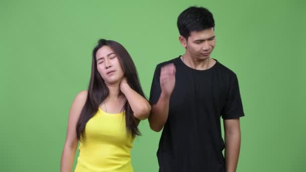 Joven pareja asiática teniendo dolor de cuello juntos — Vídeos de Stock