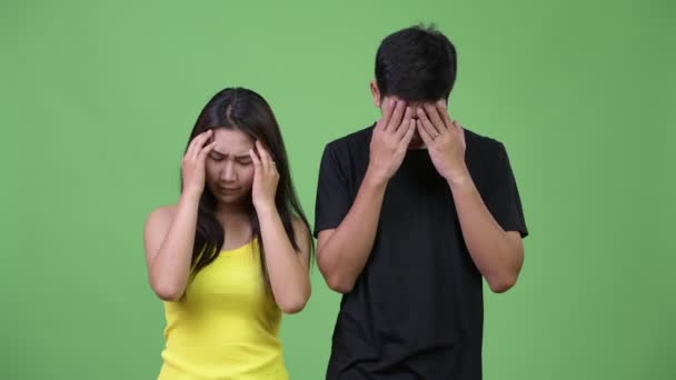 Молодая азиатская пара испытывает головную боль вместе — стоковое видео