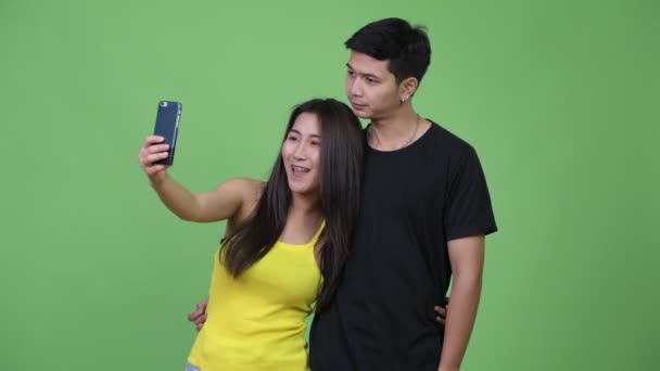 Jovem feliz casal asiático tomando selfie juntos — Vídeo de Stock