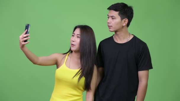 Jeune heureux asiatique couple vidéo appel ensemble — Video