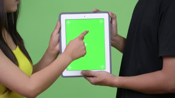 Joven pareja asiática utilizando tableta digital juntos — Vídeo de stock
