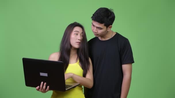 Jovem feliz casal asiático usando laptop juntos — Vídeo de Stock